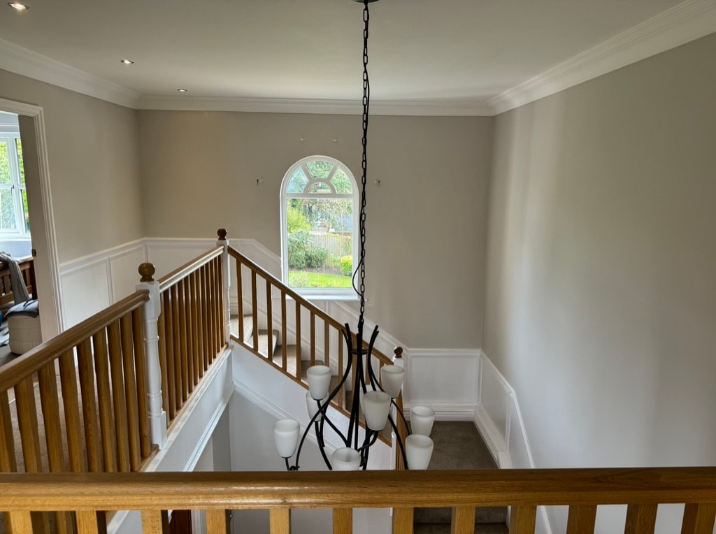 Elegant hallway with wooden staircase and chandelier — decorating project
