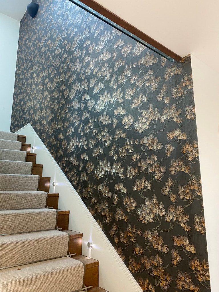 Staircase with patterned wallpaper accent wall — decorating project
