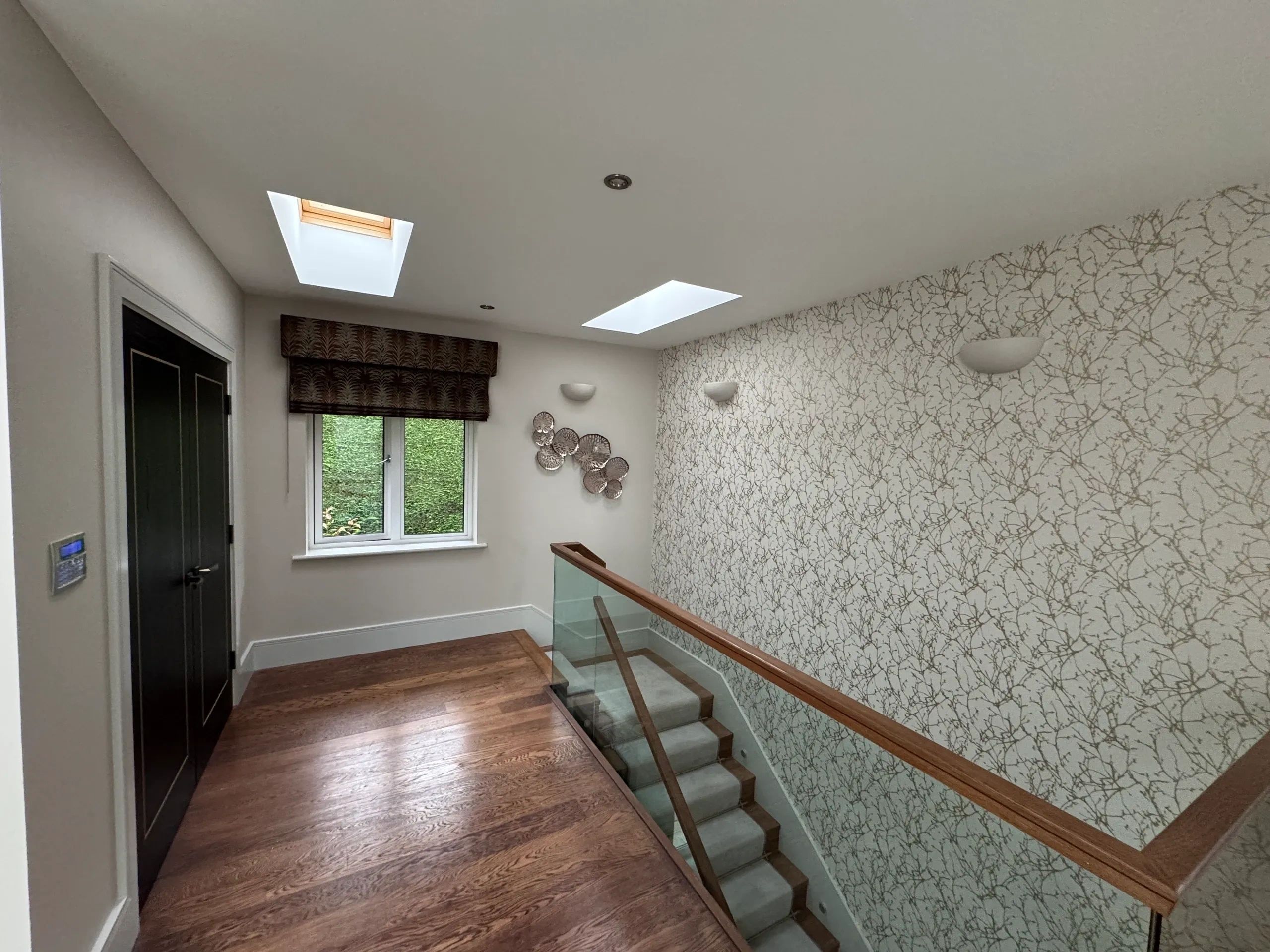 Hallway and staircase with glass panels and patterned wallpaper